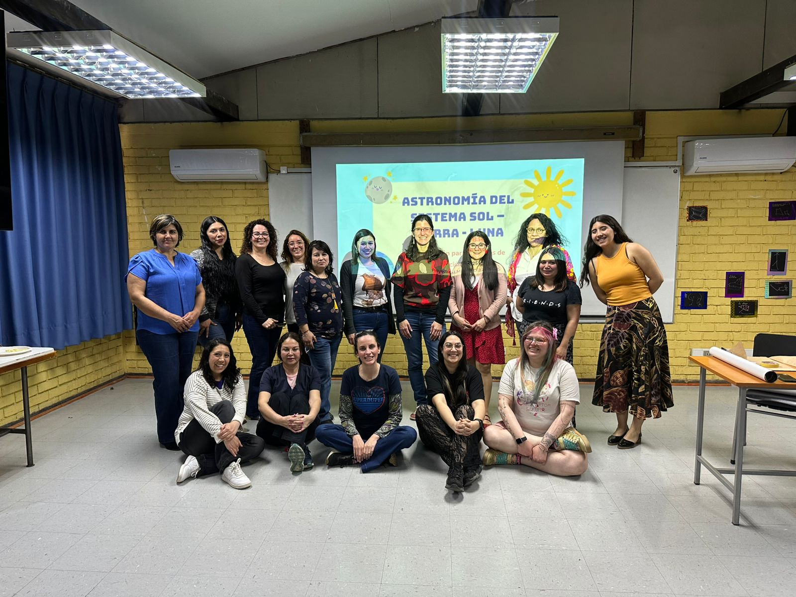 Grupo de mujeres, profesoras, posando para una foto en una sala de clases.