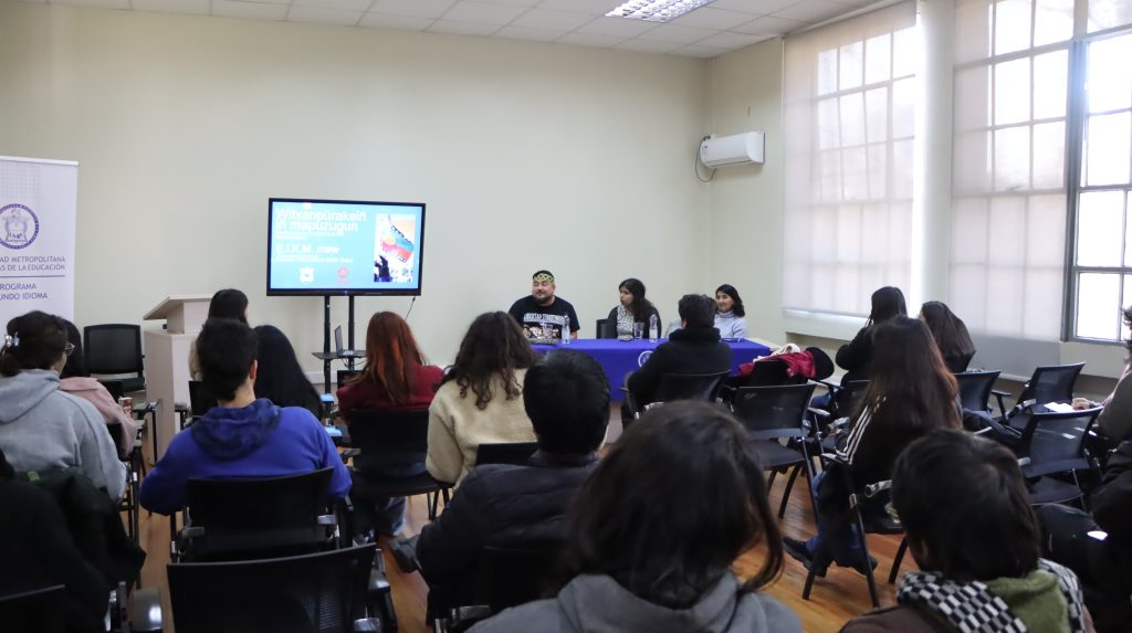 Fotografía de personas sentadas mirando a las personas que exponen en el conversatorio sobre revitalización lingüística del mapudungun