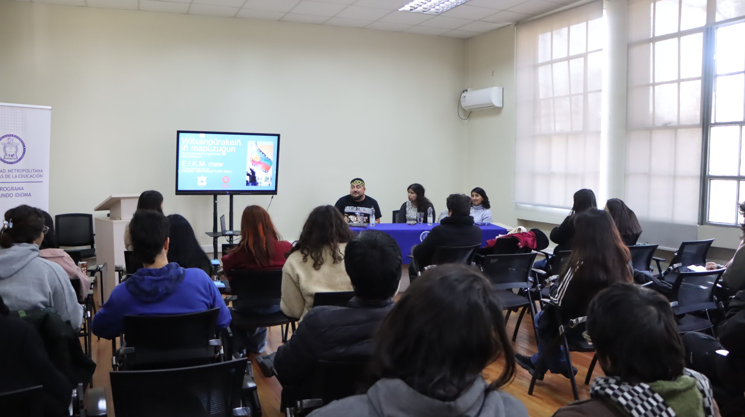 Fotografía de personas sentadas mirando a las personas que exponen en el conversatorio sobre revitalización lingüística del mapudungun